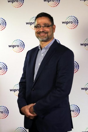 Wipro CEO Abidali Neemuchwala posing with the new Wipro logo. wipro, wipro unveils new logo, wipro ceo abidali neemuchwala, wipro chairman azim premji