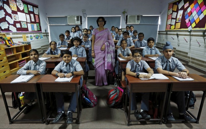Teacherwith 7th-grade level students inside their classroom in a New Delhi school. School