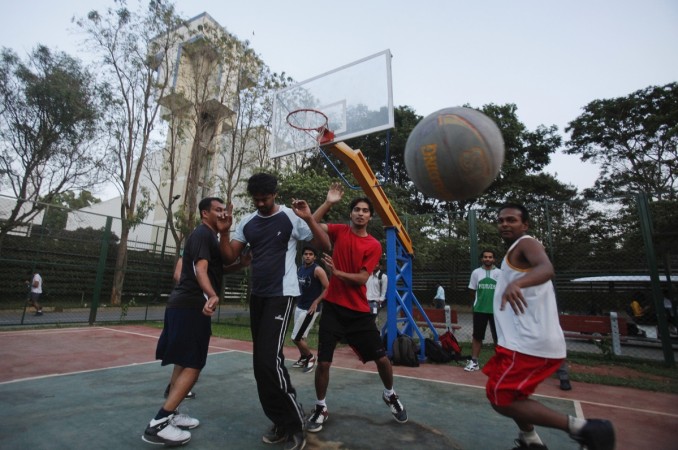Employees of IT companies play on a basketball court after work at the Electronics City IT district in Bangalore, February 28, 2012. layoffs, layoffs at it companies, it hiring, it recruitment, layoffs at wipro, layoffs at infosys, layoffs at capgemini, layoffs at cognizant, it stocks, tcs share price, h-1 b visa controversy