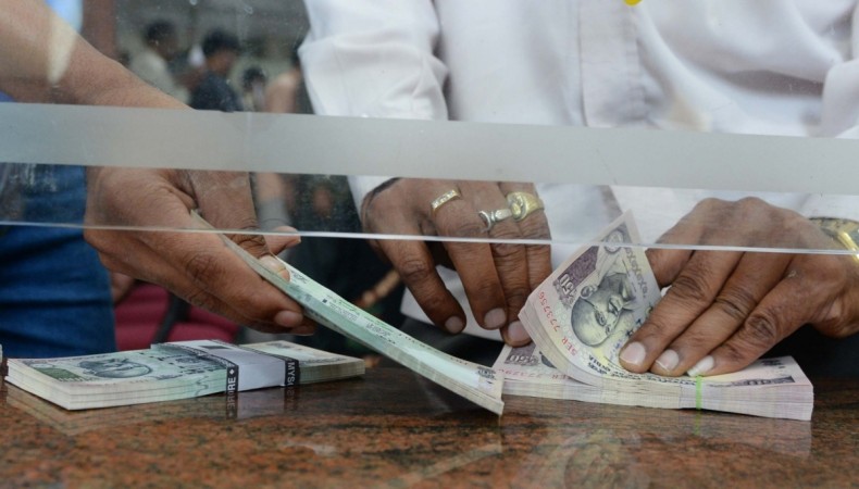 A man counting new Rs 100 currency notes in exchange of the old Rs 500 and Rs 1,000 notes at a bank counter in Bengaluru on Nov 10, 2016. personal finance, mf investments, mutual funds, reliance growth fund, returns on reliance growth fund, reliance mf, mf schemes, indian mutual funds