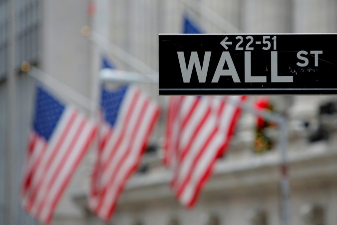 A street sign for Wall Street is seen outside the New York Stock Exchange (NYSE) in New York City, U.S., December 28, 2016. wall street, us investments, us stock markets, donald trump effect on stock markets, djia