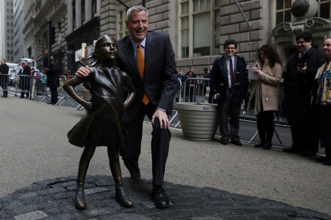 New York City Mayor Bill de Blasio poses next to the Fearless Girl