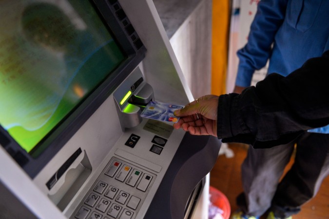 A man inserts his card to withdraw money from a mobile bank ATM machine in New Delhi on November 15, 2016. bank, banks, atm, cash, note ban, demonetisation, modi govt, no cash, rbi, bank deposits