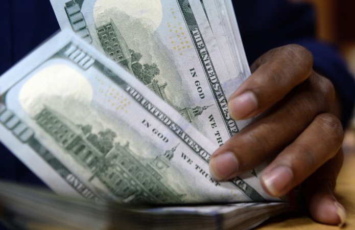 An Indian forex dealer counts US $100 currency notes in Mumbai on August 25, 2015. india, india forex reserves, rbi, foreign exchange reserves, fii, fpi, fdi, modi govt, arun jaitley, india trade