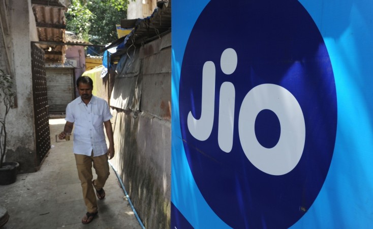 A man walks past a Reliance Jio Infocomm 4G mobile services logo in Mumbai on September 6 2016. Reliance Jio