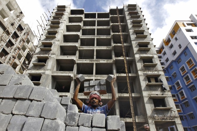 A labourer stacks concrete blocks on his head at the construction site of a residential complex on the outskirts of Kolkata in this November 2, 2015 file photo. India's infrastructure output grew at its fastest pace in four months to 3.2 percent in September from a year ago, mainly driven by higher production of electricity and fertilisers, government data showed on Monday. REUTERS/Rupak De Chowdhuri Real estate
