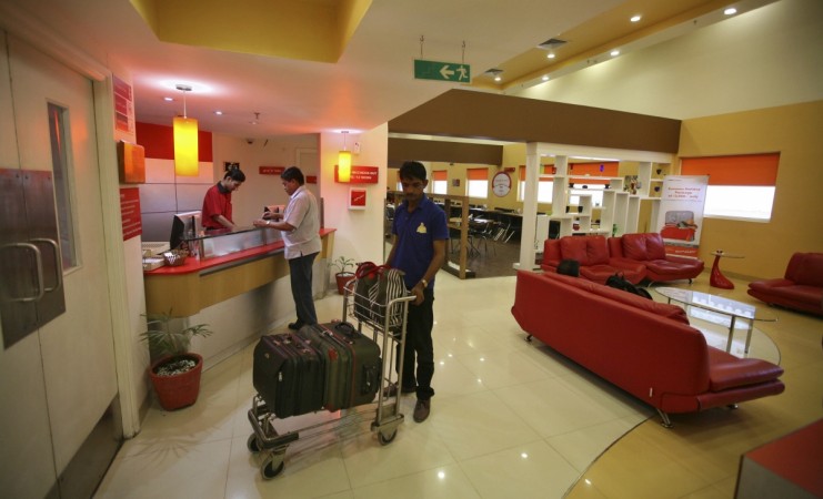 An attendant holds a trolley loaded with the luggage of a guest at the reception area of the Tata Group's Indian Hotels Co. Ginger chain in the western Indian city of Ahmedabad May 5, 2012. gst on hotels, gst on restaurants, 5 star hotels, luxury hotels, gst on 5 star hotels, gst hotels 18%, gst hotels 28%, gst council, fm arun jaitley
