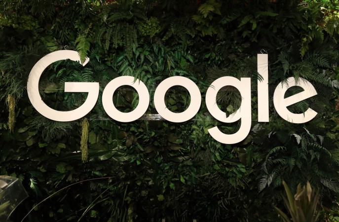 The Google logo hangs among plants at a juice stand at the W20 conference on April 25, 2017, in Berlin, Germany. Google