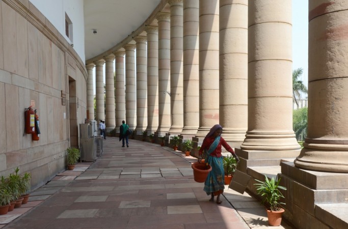 Workers clean in preparation for the newly elected members of the upcoming 16th Parliament at Parliament House in New Delhi on May 15, 2014. parliament, monsoon session, lok sabha, rajya sabha, gst, cattle, bjp, congress, pm modi, arun jaitley