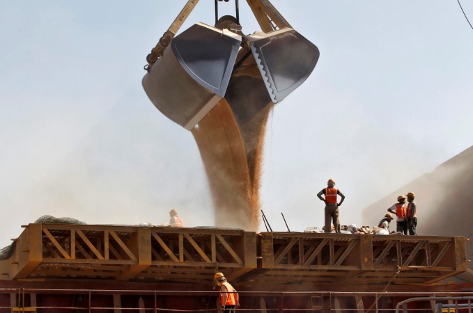 Workers stand around a crane as it loads wheat onto a ship at Mundhra Port in Gujarat in this file photo. REUTERS/Amit Dave India economy
