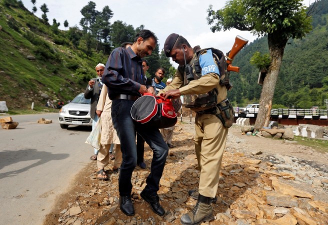 An Indian security force personnel (R) checks the bag of a man near a base camp of Hindu pilgrimage to the cave of Amarnath after seven Hindu pilgrims were killed in a gunbattle between Indian police and militants on Monday, in Langanbal village in south Kashmir's Anantnag district July 11, 2017. Amarnath Yatra