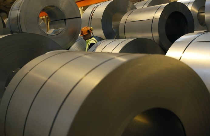 A worker walks through coils of steel to be used on Tata Steel's new robotic welding line at the company's Automotive Service Centre in Wednesfield, Britain, on February 15, 2017. Tata Steel