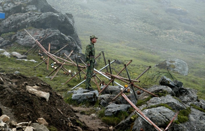 A Chinese soldier stands guard on the Chinese side of the Nathu La border crossing between India and China. Nathu La