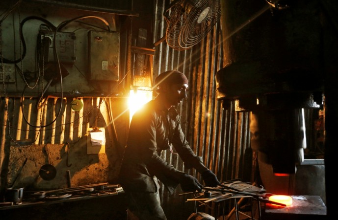 A worker operates a hydraulic press machine at a workshop manufacturing flanges for automobiles in Mumbai, India, May 29, 2017. Picture taken May 29, 2017. REUTERS/Shailesh Andrade GDP