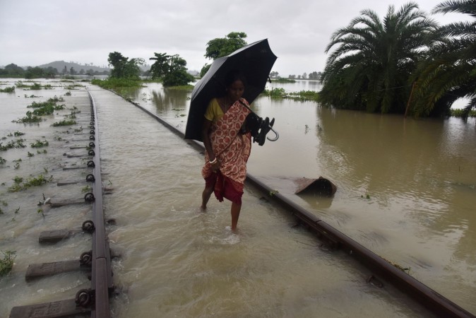 An Indian villager walks along a submerged railway track in the flood-affected Jakhalabandha area in Koliabor, some 186km from Guwahati, the capital city of Indias northeastern state of Assam on August 14, 2017. Assam floods