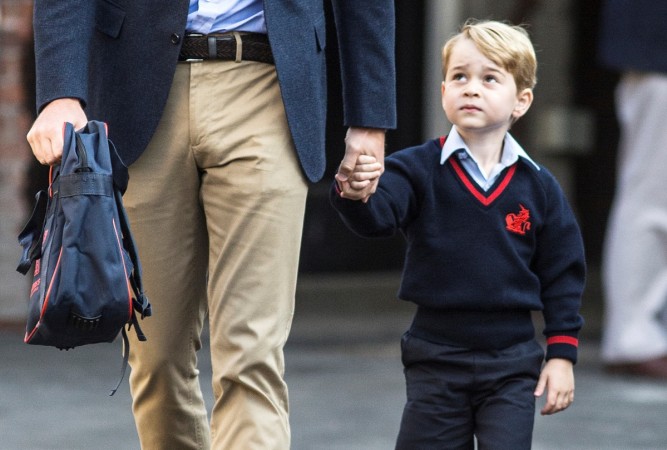   Prince George is holding the hand of his father, Prince William, while he arrives at his first day of school at the University. Thomas School in Battersea, London. The hand of the British Prince William on his arrival at the Thomas School in Battersea, London 