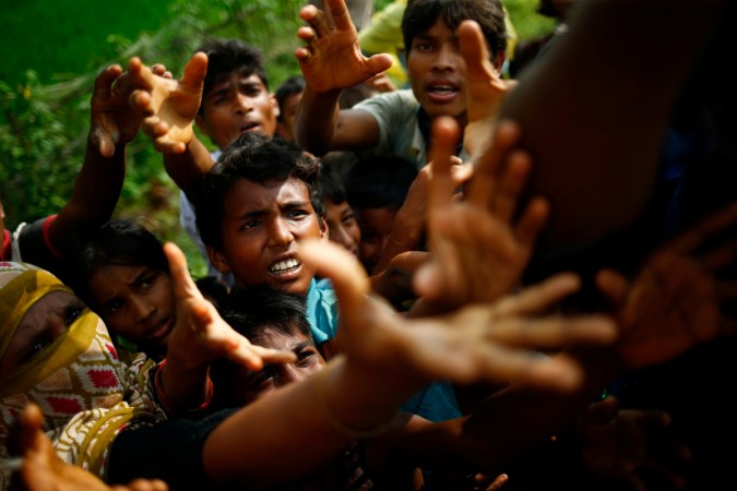 Rohingya refugees stretch their hands for food near Balukhali in Cox's Bazar, Bangladesh. Rohingya refugees stretch their hands for food near Balukhali in Cox's Bazar, Bangladesh.