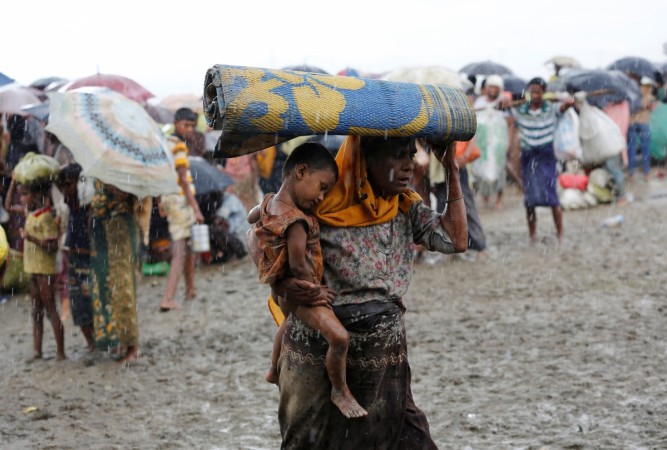 Rohingya refugees walk in the rain as they are held by the Border Guard Bangladesh (BGB) after illegally crossing the border, in Teknaf, Bangladesh. Rohingya refugees walk in the rain as they are held by the Border Guard Bangladesh (BGB) after illegally crossing the border, in Teknaf, Bangladesh.