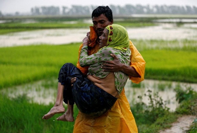 A local man carries an old Rohingya refugee woman as she is unable to walk after crossing the border, in Teknaf, Bangladesh A local man carries an old Rohingya refugee woman as she is unable to walk after crossing the border, in Teknaf, Bangladesh