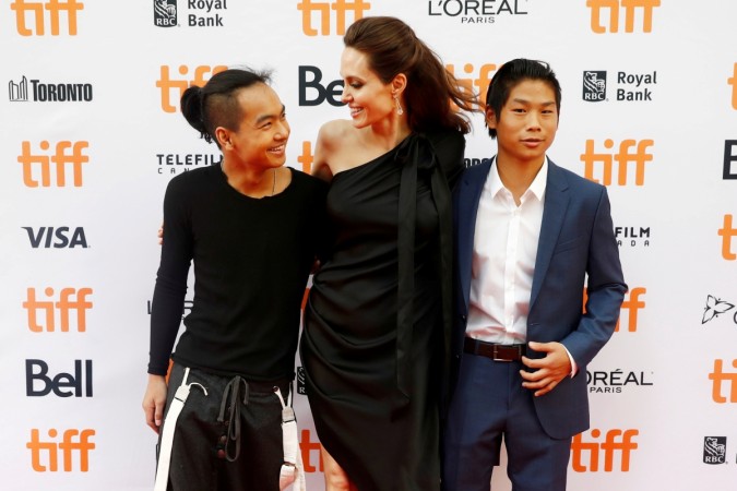Director Angelina Jolie arrives with her sons Maddox Jolie-Pitt (L), and Pax Jolie-Pitt (R) on the red carpet for the film Angelina Jolie