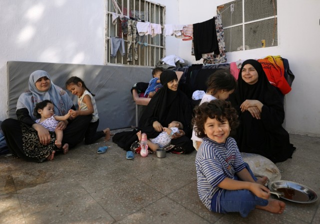 Wives of former Islamic State fighters, sit with their children at a camp for displaced people ISIS wives