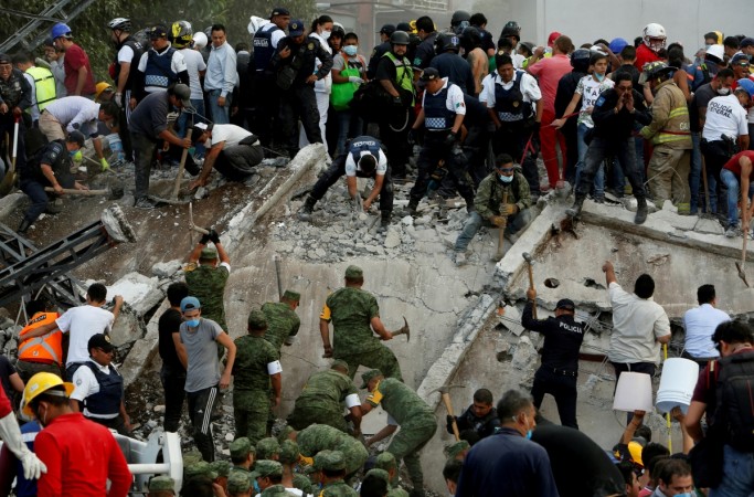 Rescuers, firefighters, policemen, soldiers and volunteers remove rubble and debris from a flattened building in search of survivors after a powerful quake in Mexico City on September 19, 2017 mexico earthquake