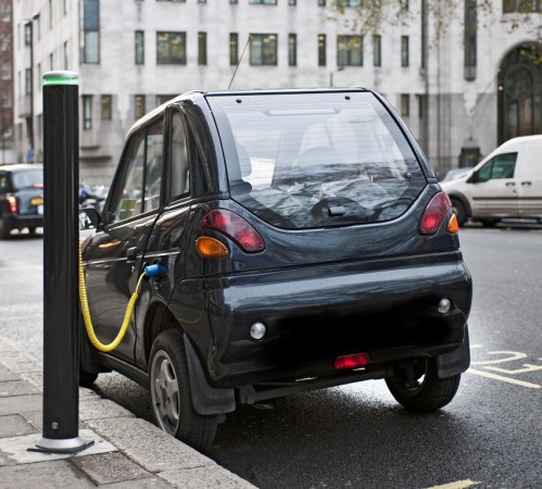Electric car being charged in city street electric car