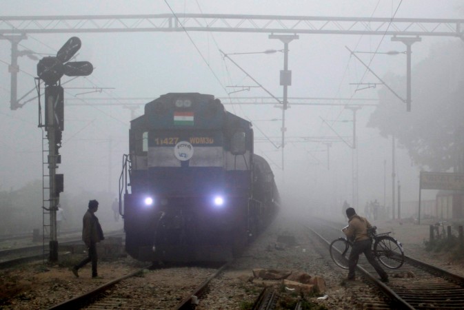 People cross a railway track in front of an arriving train on a foggy winter morning in Allahabad in this November 30, 2016, file photo. REUTERS/Jitendra Prakash Railways
