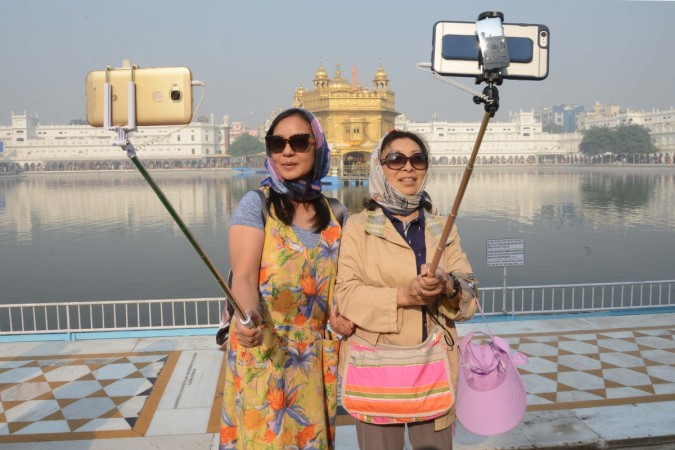 In picture: Tourists take a 'selfie' at the Golden Temple in Amritsar on November 14, 2016, as Sikh devotees mark the 547th birth anniversary of Sri Guru Nanak Dev. Chinese tourists in India