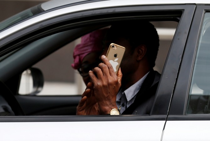 A man uses his mobile phone as he drives his car in central Brussels Driving distractions, Car tech