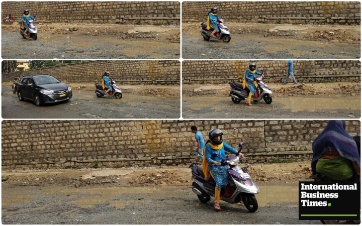 A lady struggling to ride through the Kaggadasapura Main Road Potholes, Bangalore potholes