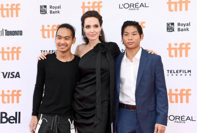 (L-R) Maddox Jolie-Pitt, Angelina Jolie, and Pax Jolie-Pitt attend the World Premiere of Netflix's Film's 'First They Killed My Father' during the Toronto International Film Festival at Princess of Wales Theatre Angelina Jolie with sons Maddox Jolie-Pitt and Pax Jolie-Pitt