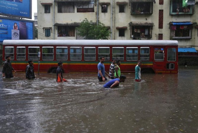 People wade through a water-logged road past a stalled passenger bus during rains in Mumbai, August 29, 2017. REUTERS/Shailesh Andrade People wade through a water-logged road past a stalled passenger bus during rains in Mumbai, August 29, 2017.