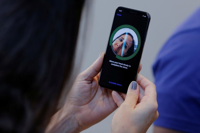 A woman sets up her facial recognition as she looks at her Apple iPhone X at an Apple store in New York, U.S., November 3, 2017. iPhone X Face ID