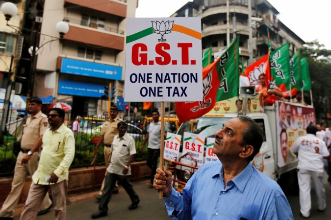 A supporter of India's ruling Bharatiya Janata Party (BJP) holds a placard during a rally to support implementation of the Goods and Services Tax (GST) in Mumbai, India, June 30, 2017. gst 1