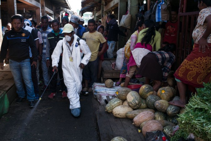 People stand back as a council worker sprays disinfectant during the clean-up of the market of Anosibe in the Anosibe district, one of the most unsalubrious districts of Antananarivo, Madagascar Black Death Plague