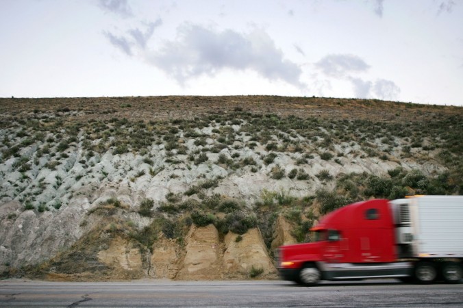 A truck crosses the San Andreas Fault, visible as the line between grey metamorphic quartz monzonite and brown sedimentary sandstone and siltstone San Andreas Fault