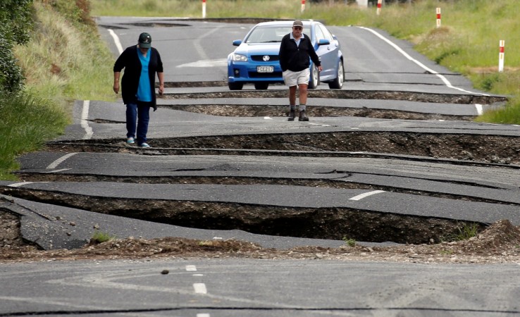 Local residents Chris and Viv Young look at damage caused by an earthquake, along State Highway One near the town of Ward New Zealand