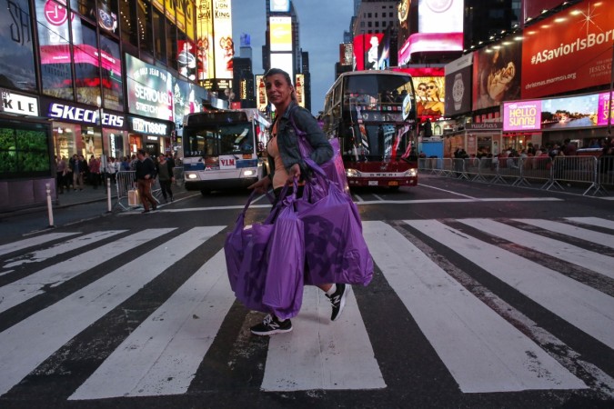 A woman carries shopping bags as she walks in Times Square in New York City. Times Square