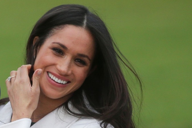 US actress Meghan Markle shows off her engagement ring she poses with her fiancée Britain's Prince Harry in the Sunken Garden at Kensington Palace in west London on November 27, 2017 Meghan Markle