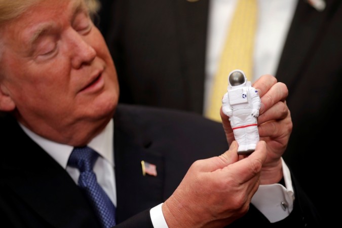 U.S. President Donald Trump holds a space astronaut toy as he participates in a signing ceremony for Space Policy Directive Donald Trump