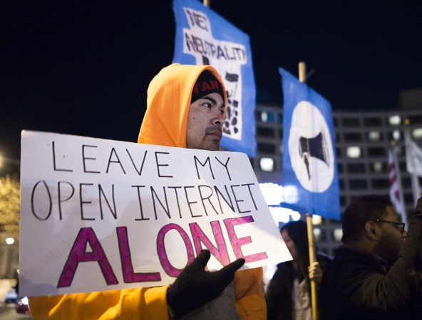 A small group of protestors supporting net neutrality protest against a plan by Federal Communications Commission (FCC) head Ajit Pai, during a demonstration on December 7, 2017 in Washington. Demonstrations in support of net neutrality are planned nationwide at hundreds of Verizon stores and other venues. net neutrality