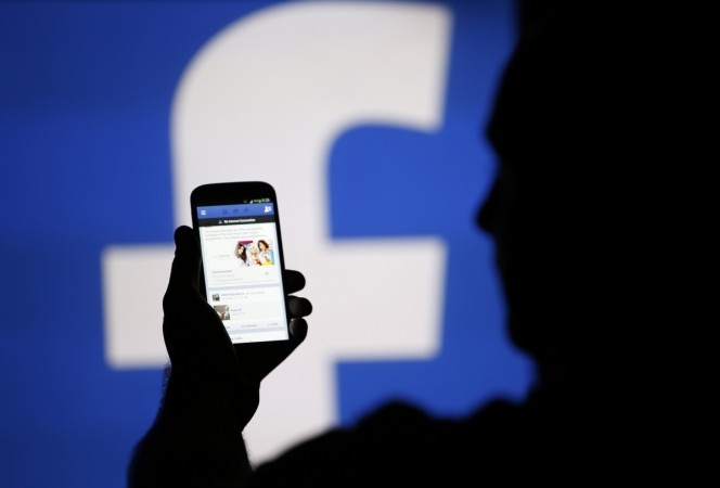 A man is silhouetted against a video screen in this photo illustration taken in the central Bosnian town of Zenica, August 14, 2013. Facebook