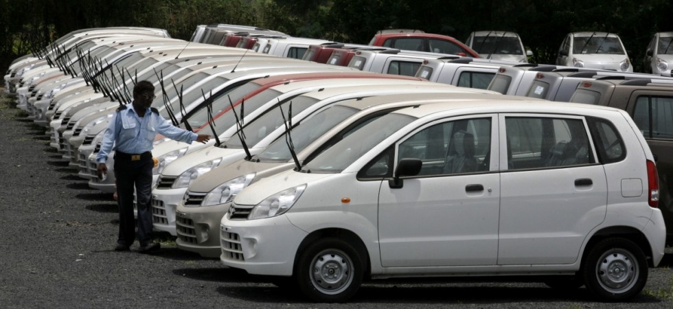 A security guard walks in front of parked cars at the Maruti Suzuki's stockyard on the outskirts of the western Indian city of western Indian city of Ahmedabad July 1, 2010. Car factory