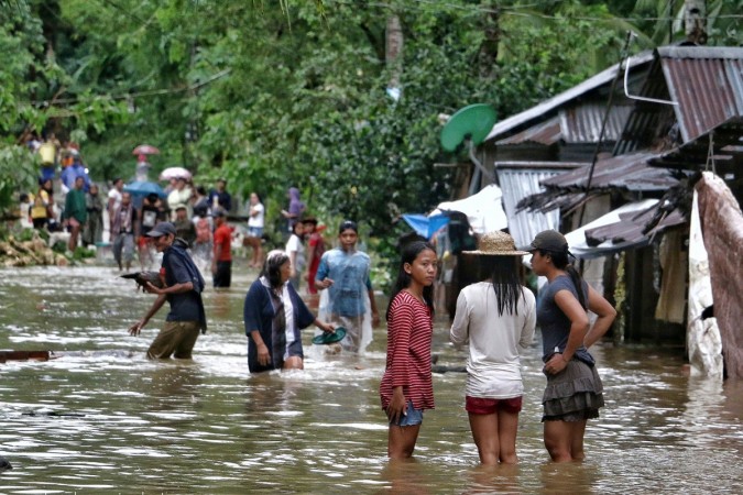 Villagers wade through a flooded street in Brgy Calingatngan, in Borongan, on easterm Samar in central Philippines on December 16, 2017. Philippines