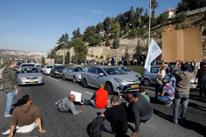 Israeli employees of Teva, the world's biggest manufacturer of generic drugs, block a main road in Jerusalem on December 17, 2017, Teva