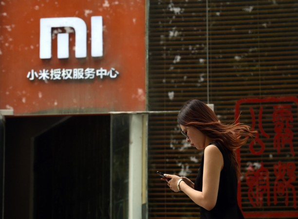 A woman walks past a Xiaomi logo outside a Xiaomi service center in Beijing on August 5, 2015. Chinese company Xiaomi was the largest smartphone vendor in China based on shipments with a 15.9 percent market share in the second quarter of 2015, according to Canalys. Telecom equipment maker Huawei was close behind at 15.7 percent, it said, followed by Apple, South Korea's Samsung and Chinese firm Vivo. CHINA-TECHNOLOGY-TELECOM-SMARTPHONE