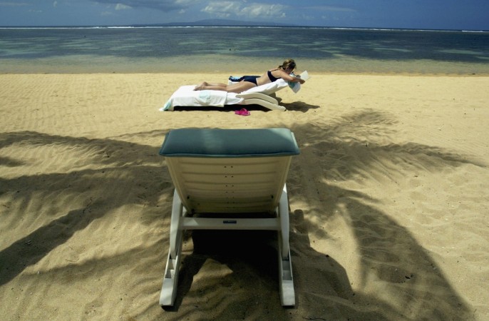 A tourist sunbathes on Sanur beach August 10, 2003 in Bali, Indonesia. Bali depends on tourism which has picked up only slightly since last year's terrorist attack. After a car bomb exploded at a luxury hotel in Indonesia's capital, Jakarta on August 5th the Balinese are again worried about further revenge attacks after the recent death sentence verdict on Amrozi, one of the key players in the Bali bombing. Bali