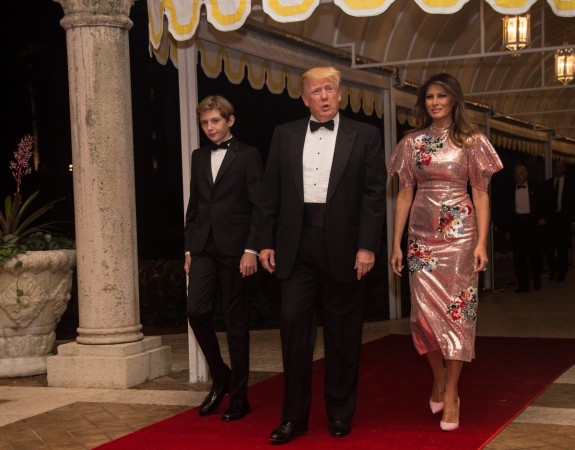 US President Donald Trump, First Lady Melania Trump and their son Barron arrive for a new year's party at Trump's Mar-a-Lago resort in Palm Beach, Florida, on December 31, 2017. Melania Trump dresses