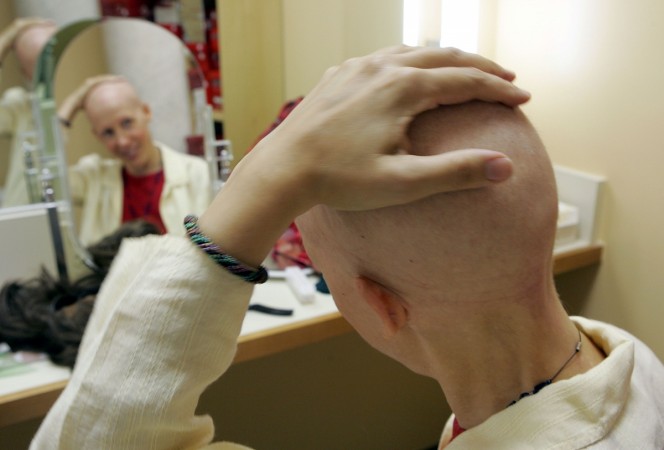 Breast cancer patient Susanne Ostlund rubs her head before trying on a wig at the Friend to Friend store at the UCSF Comprehensive Cancer Center August 17, 2005 in San Francisco, California. UCSF Cancer Center Uses Latest Technologies To Battle Cancer